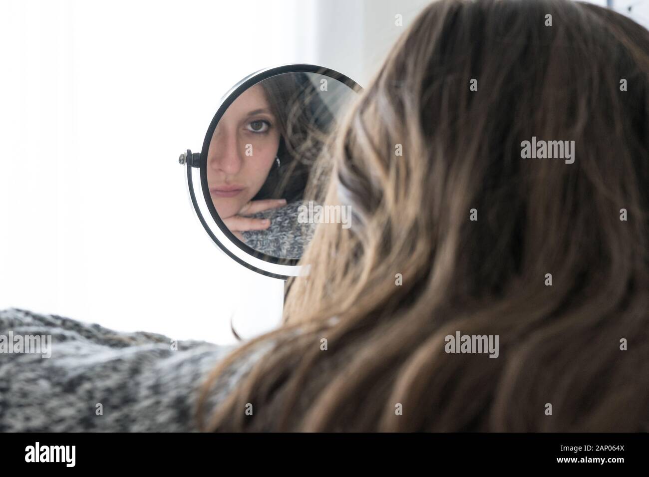Femme déprimée se regarde dans le miroir avec visage triste. Concept de la maladie mentale chez les jeunes femme Banque D'Images