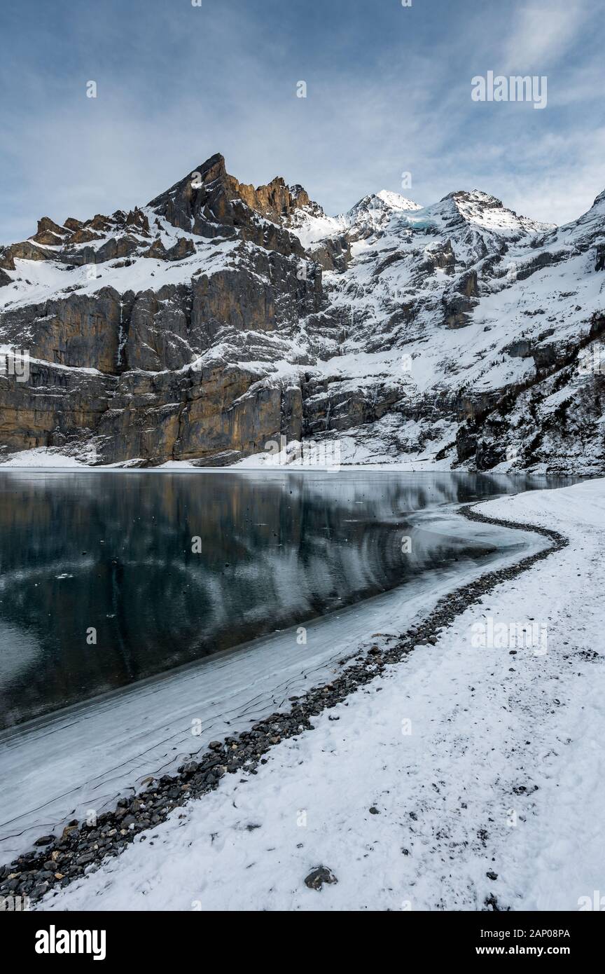 Rive du lac gelé l'Oeschinensee avec Blümlisalp montagnes près de Kandersteg Banque D'Images