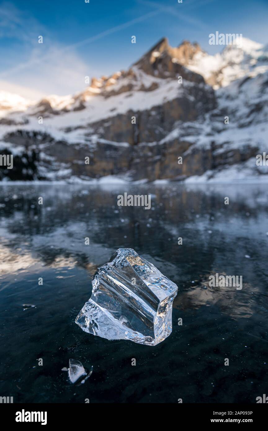 Belle bloc de glace sur un lac gelé l'Oeschinensee avec réflexion et Blümlisalp Montagnes à Berner Oberland Banque D'Images