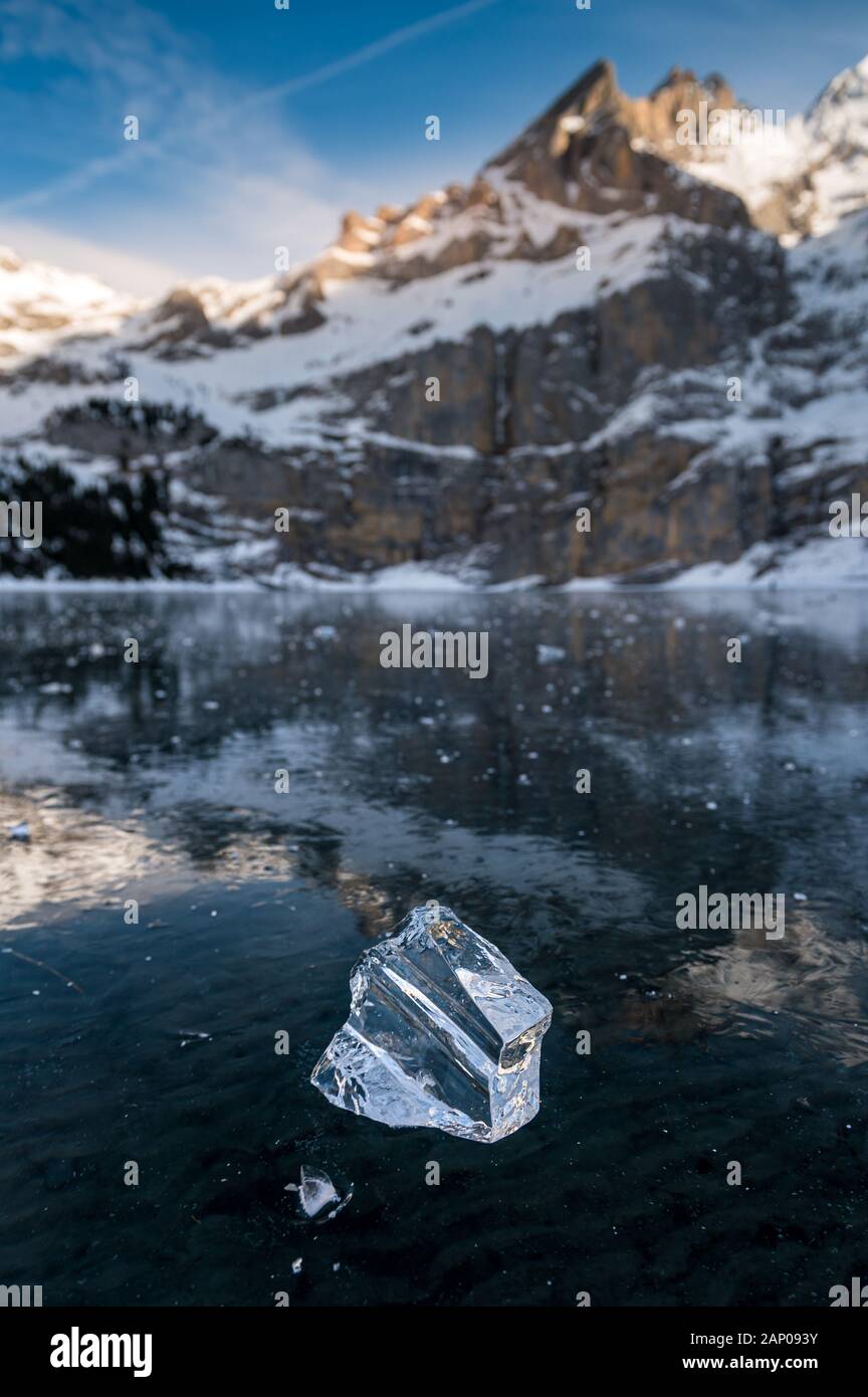Belle bloc de glace sur un lac gelé l'Oeschinensee avec réflexion et Blümlisalp Montagnes à Berner Oberland Banque D'Images