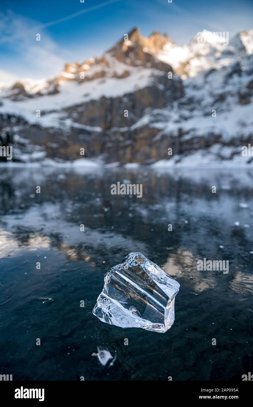 Belle bloc de glace sur un lac gelé l'Oeschinensee avec réflexion et Blümlisalp Montagnes à Berner Oberland Banque D'Images