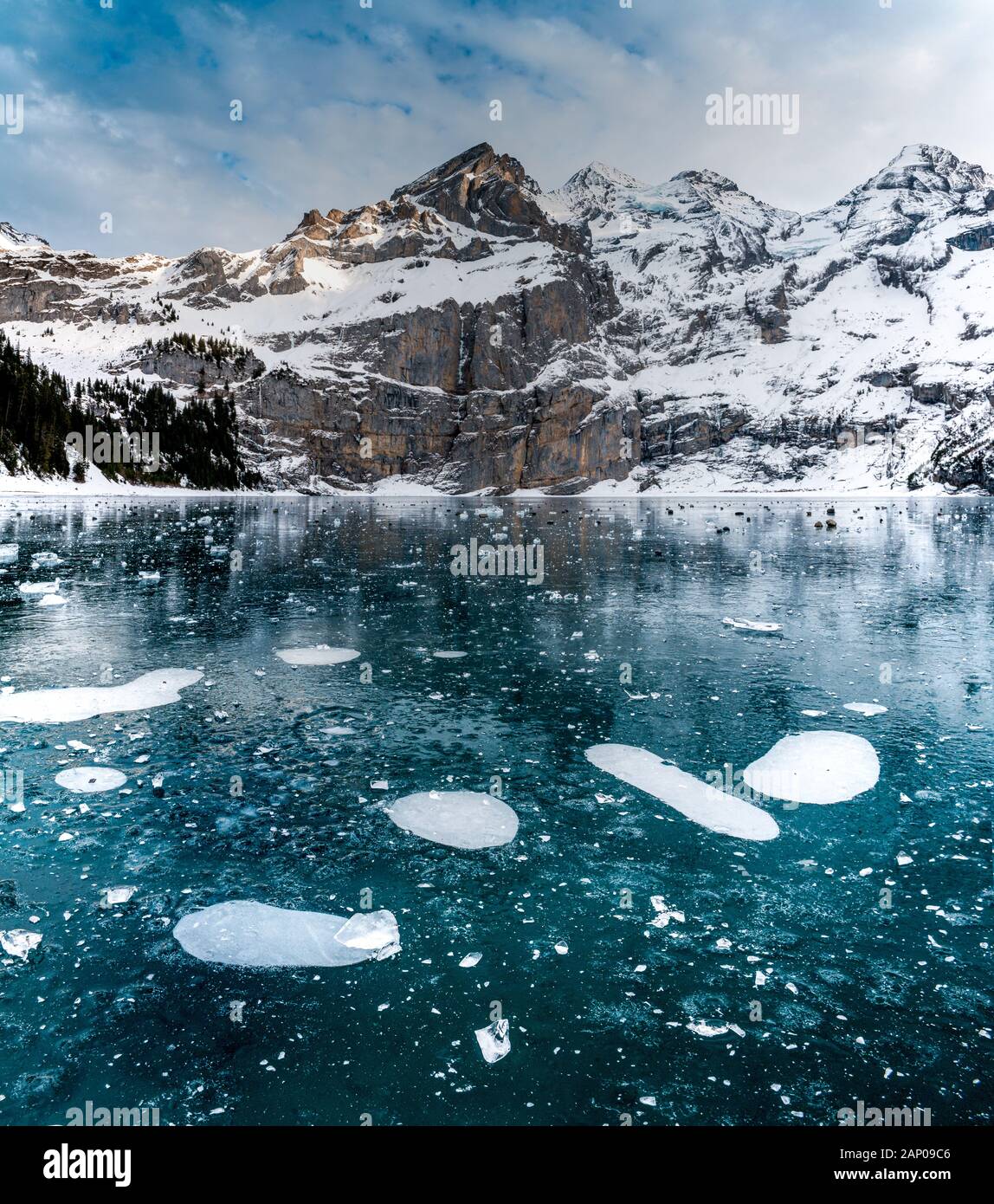 Des bulles sur le lac gelé l'Oeschinensee avec reflet de la Blümlisalp montagnes dans les Alpes Suisses Banque D'Images