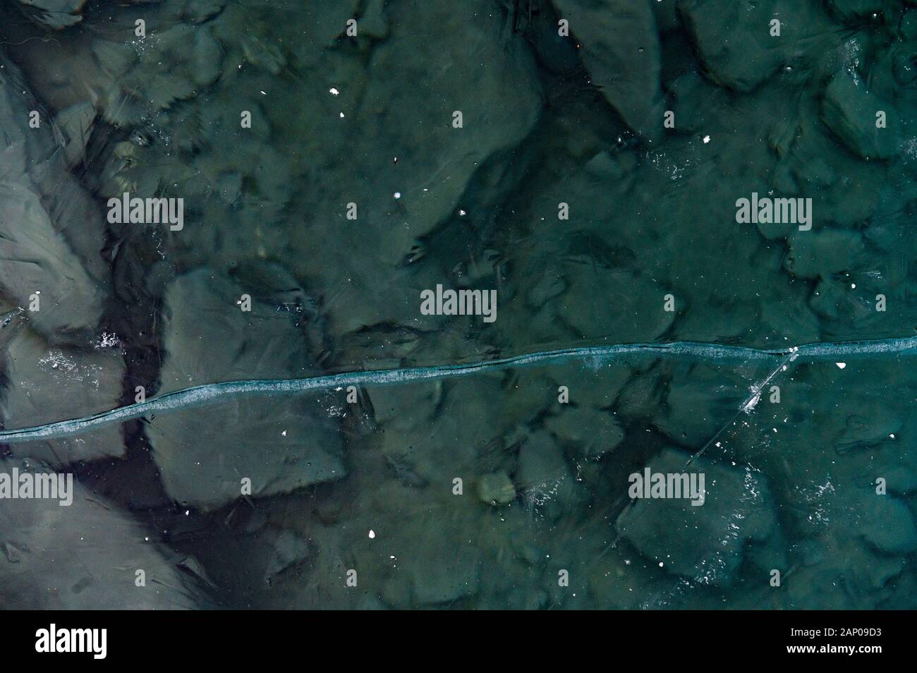 Fissure dans la glace noire structure d'un lac gelé Banque D'Images