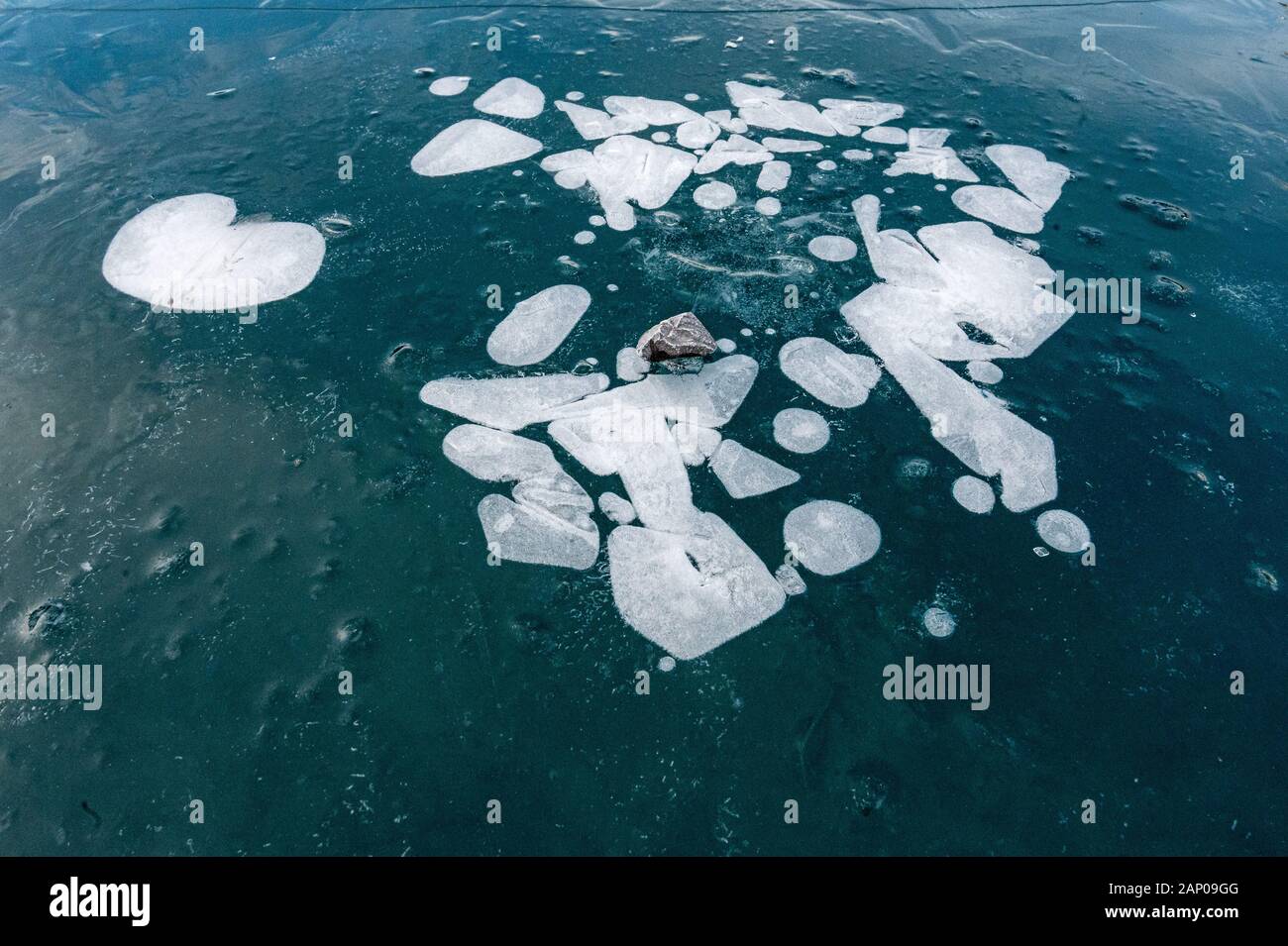 Frozen bulles dans la glace noire sur le lac Oeschinensee dans les Alpes Suisses Banque D'Images