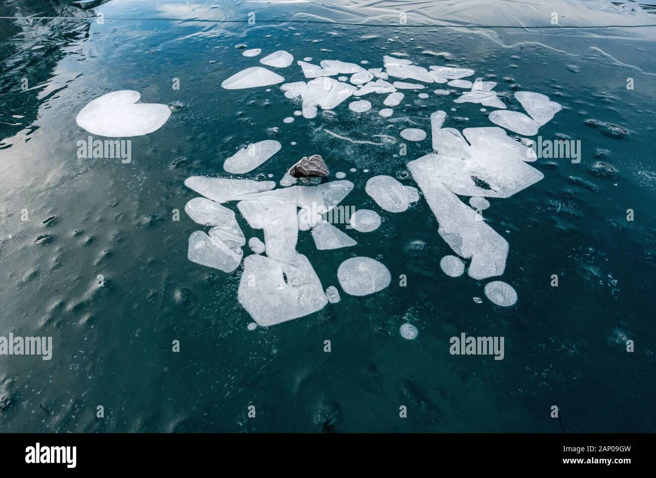 Frozen bulles dans la glace noire sur le lac Oeschinensee dans les Alpes Suisses Banque D'Images