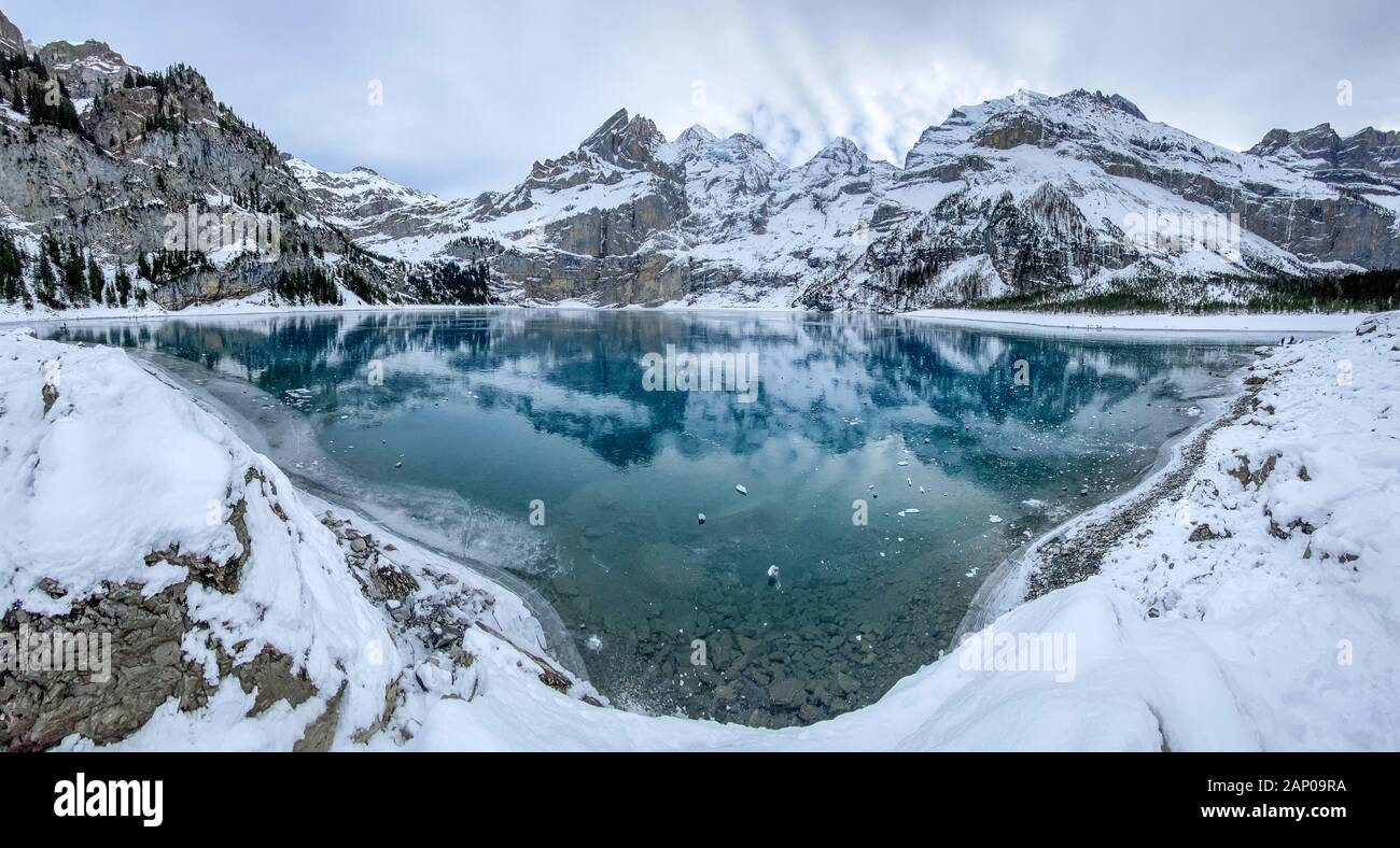 Panorama du lac gelé l'Oeschinensee avec reflet de la Blümlisalp montagnes dans les Alpes Suisses Banque D'Images