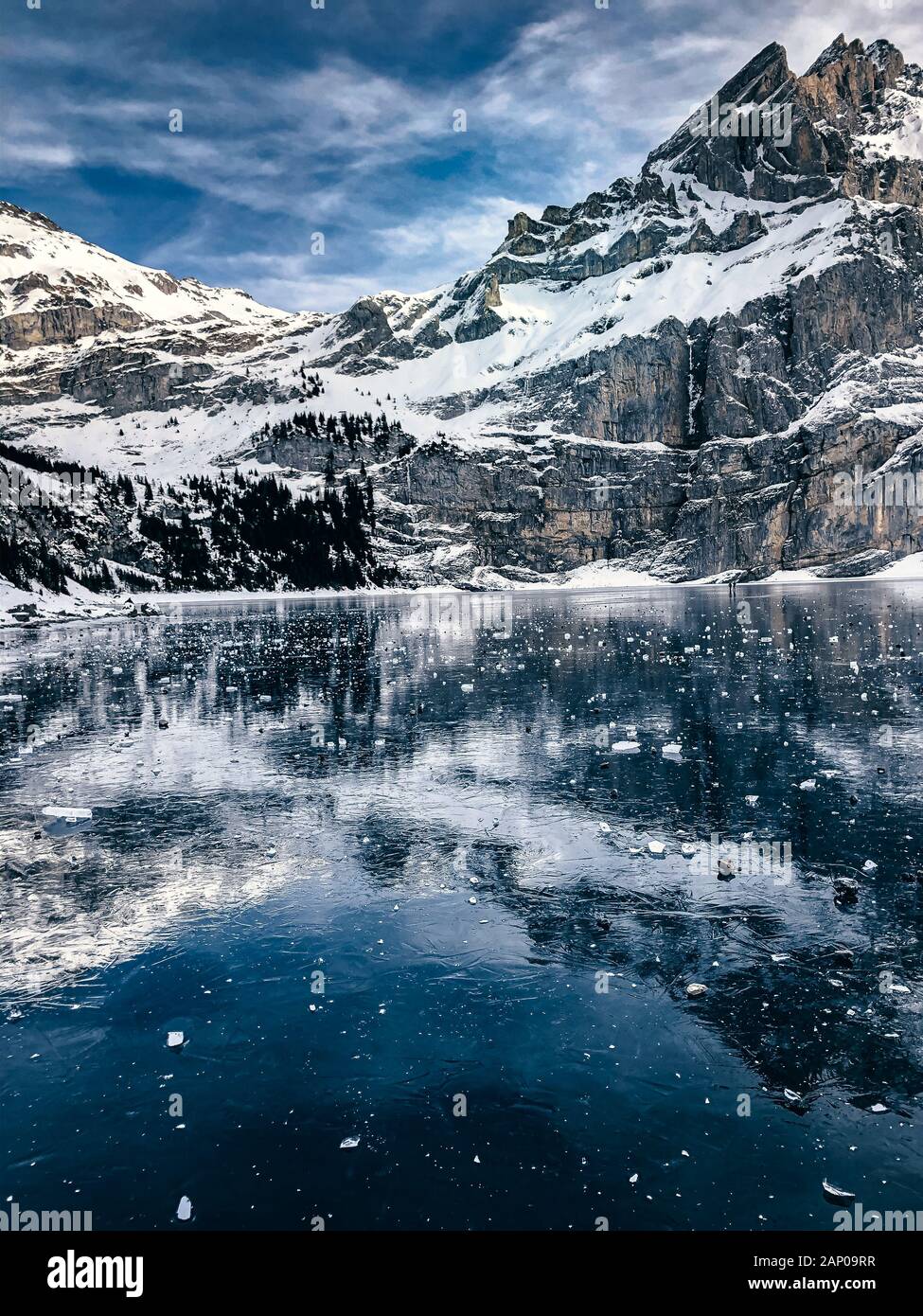 Glace de lac gelé l'Oeschinensee avec reflet de la Blümlisalp montagnes dans les Alpes Suisses Banque D'Images