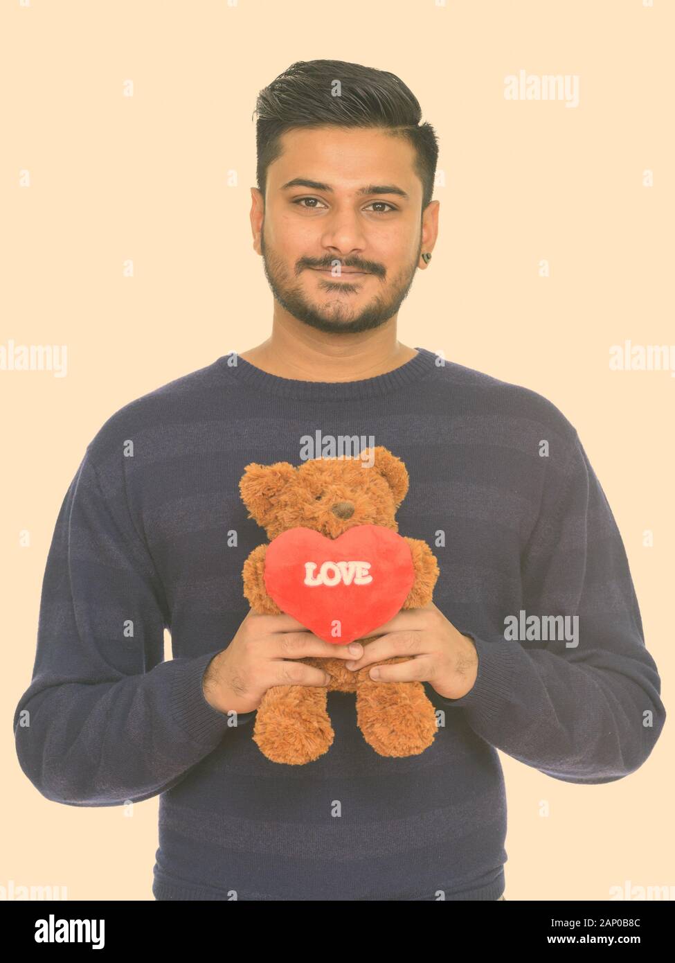 Beau jeune homme indien prêt pour la Saint-Valentin teddy bear avec amour et coeur sign Banque D'Images