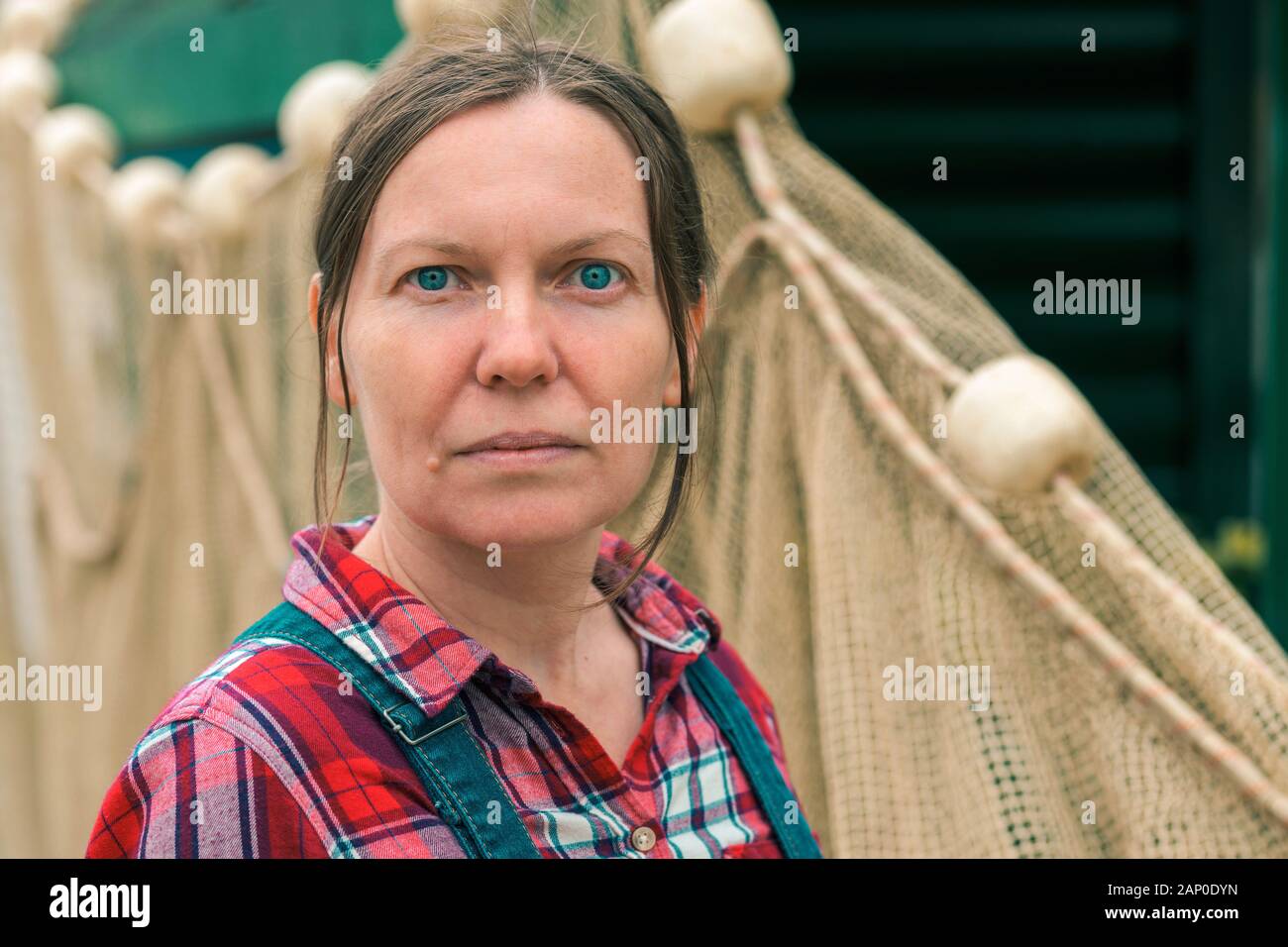 Pêcheur au filet maillant pour femmes avec un filet de poisson. Portrait de femme de race blanche adultes travaillant dans l'industrie de la pêche. Banque D'Images