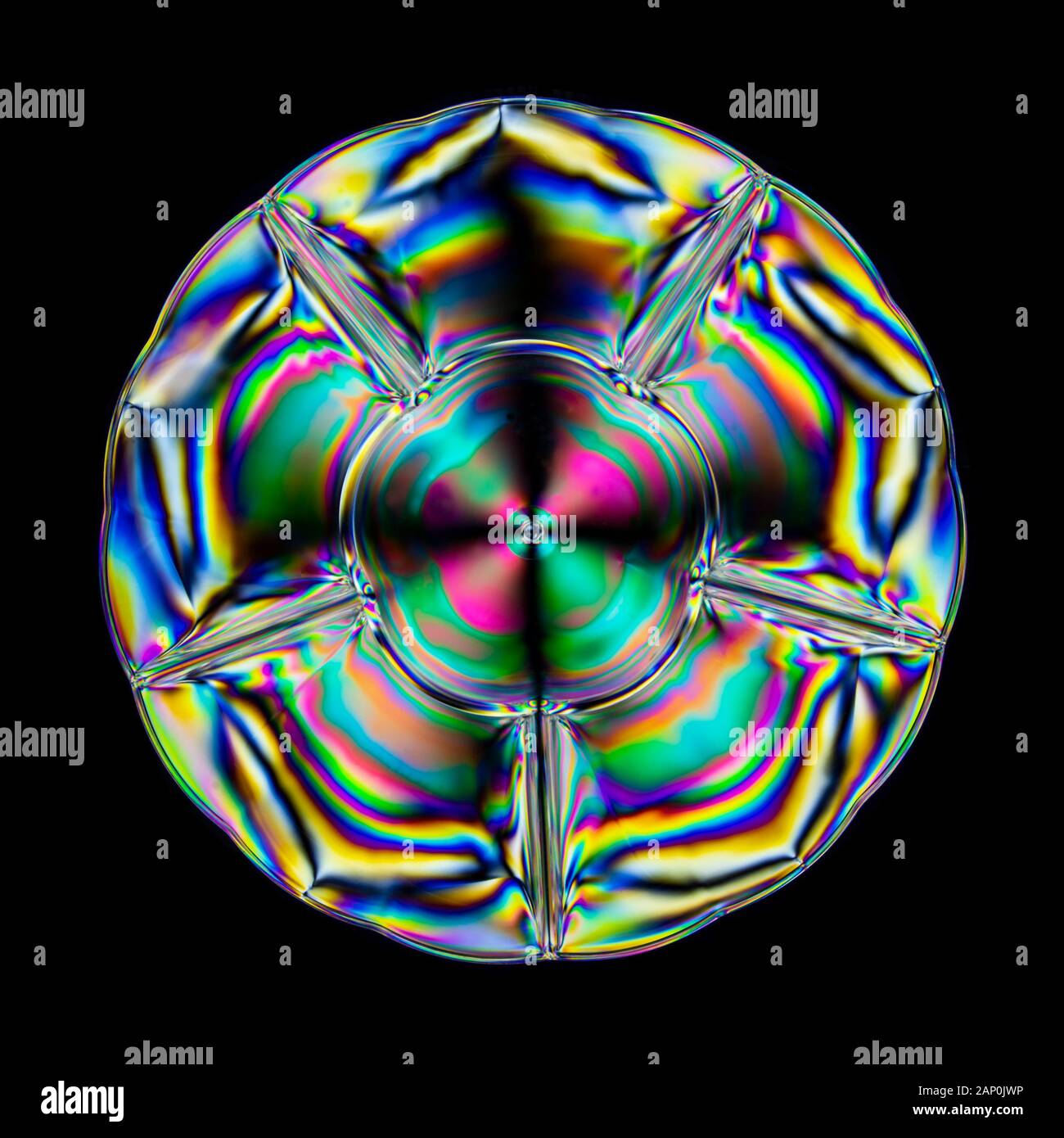 Motifs de contrainte colorés en plastique dur, révélés par l'imagerie entre deux filtres polarisants croisés. Banque D'Images