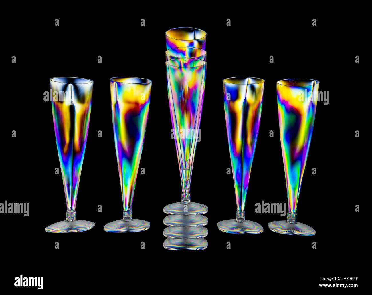 Motifs de contrainte colorés en plastique dur, révélés par l'imagerie entre deux filtres polarisants croisés montrant un motif de verres à vin en plastique Banque D'Images