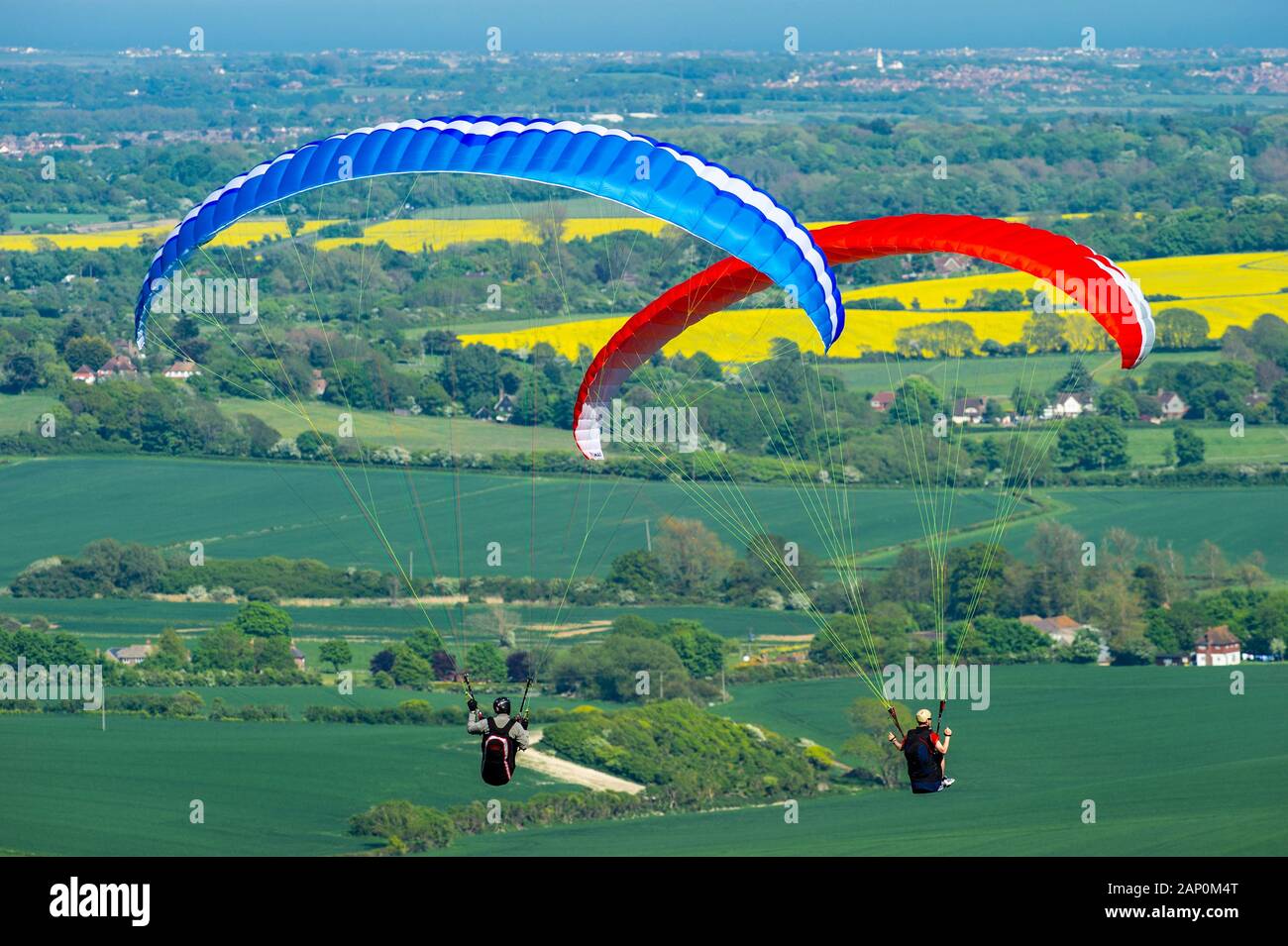 Deux pilotes de parapente voler près ensemble comme ils dominent la campagne environnante. Banque D'Images