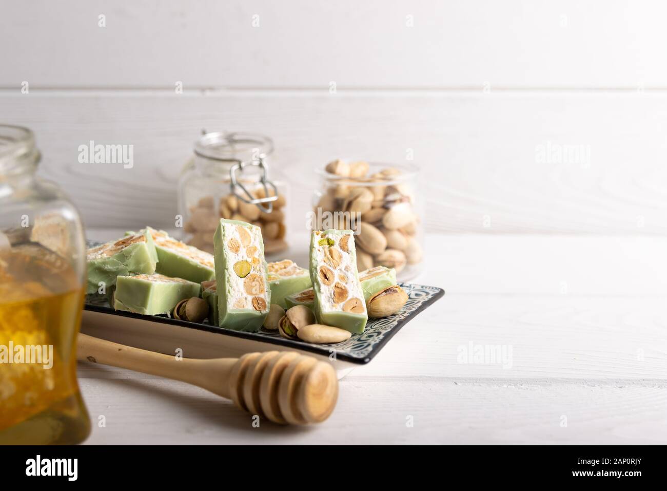 Nougat bio faites avec du miel, pistache, noisette, noix et amandes, sur un fond blanc. Banque D'Images