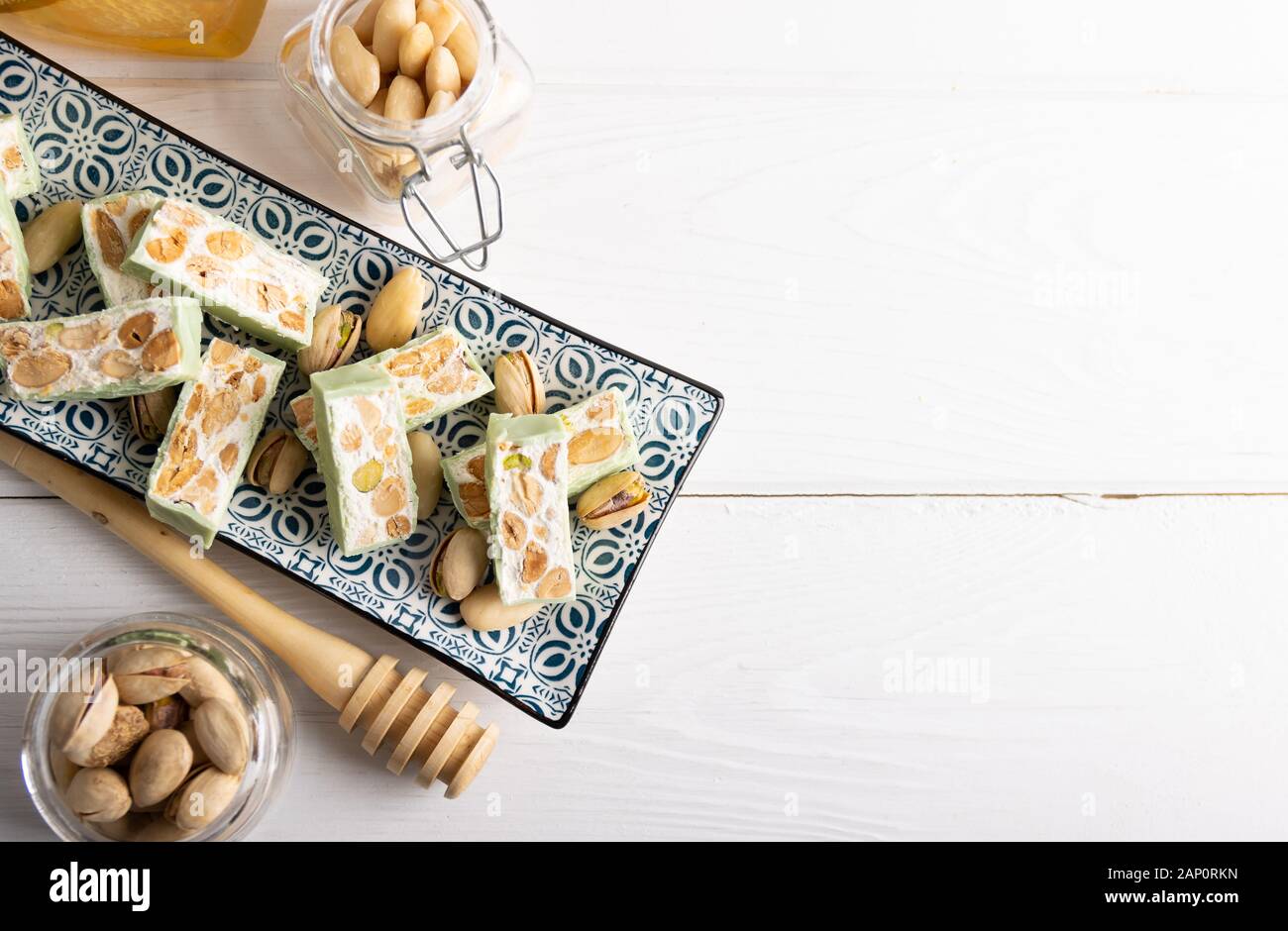 Nougat bio faites avec du miel, pistache, noisette, noix et amandes, sur un fond blanc. Banque D'Images
