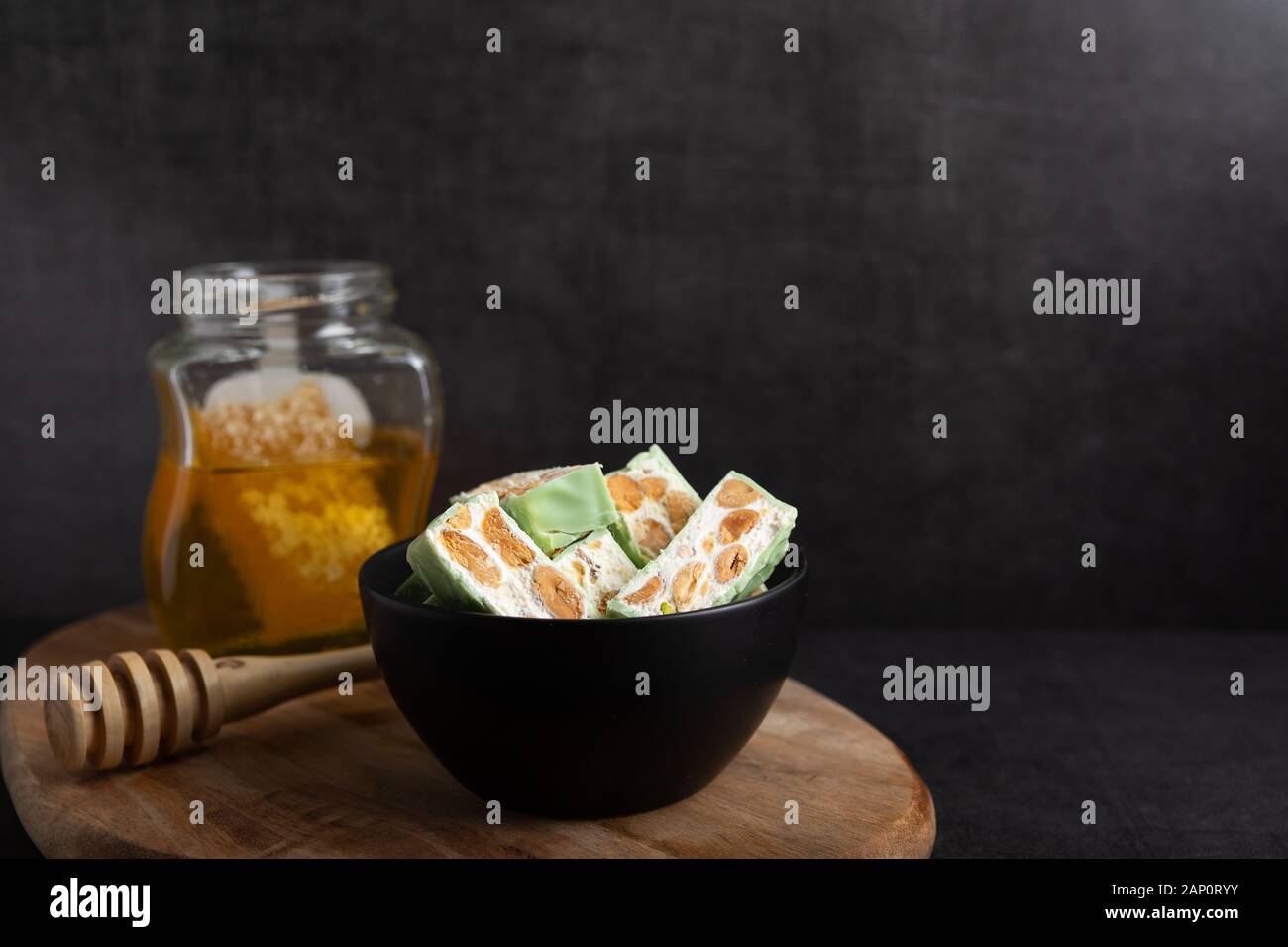 Nougat bio faites avec du miel, pistache, noisette, noix et amandes, sur un fond sombre. rustique Banque D'Images