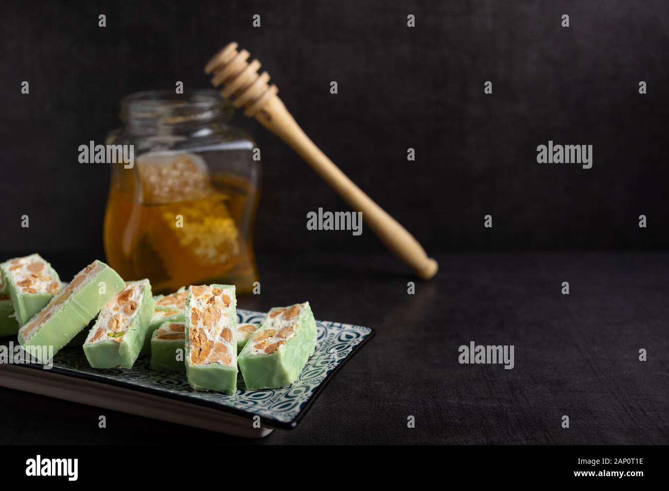 Nougat bio faites avec du miel, pistache, noisette, noix et amandes, sur un fond sombre. rustique Banque D'Images