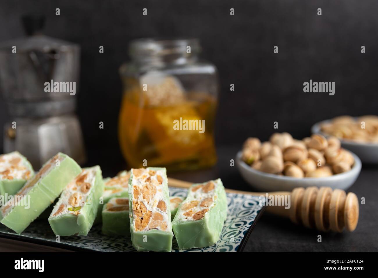 Nougat bio faites avec du miel, pistache, noisette, noix et amandes, sur un fond sombre. rustique Banque D'Images