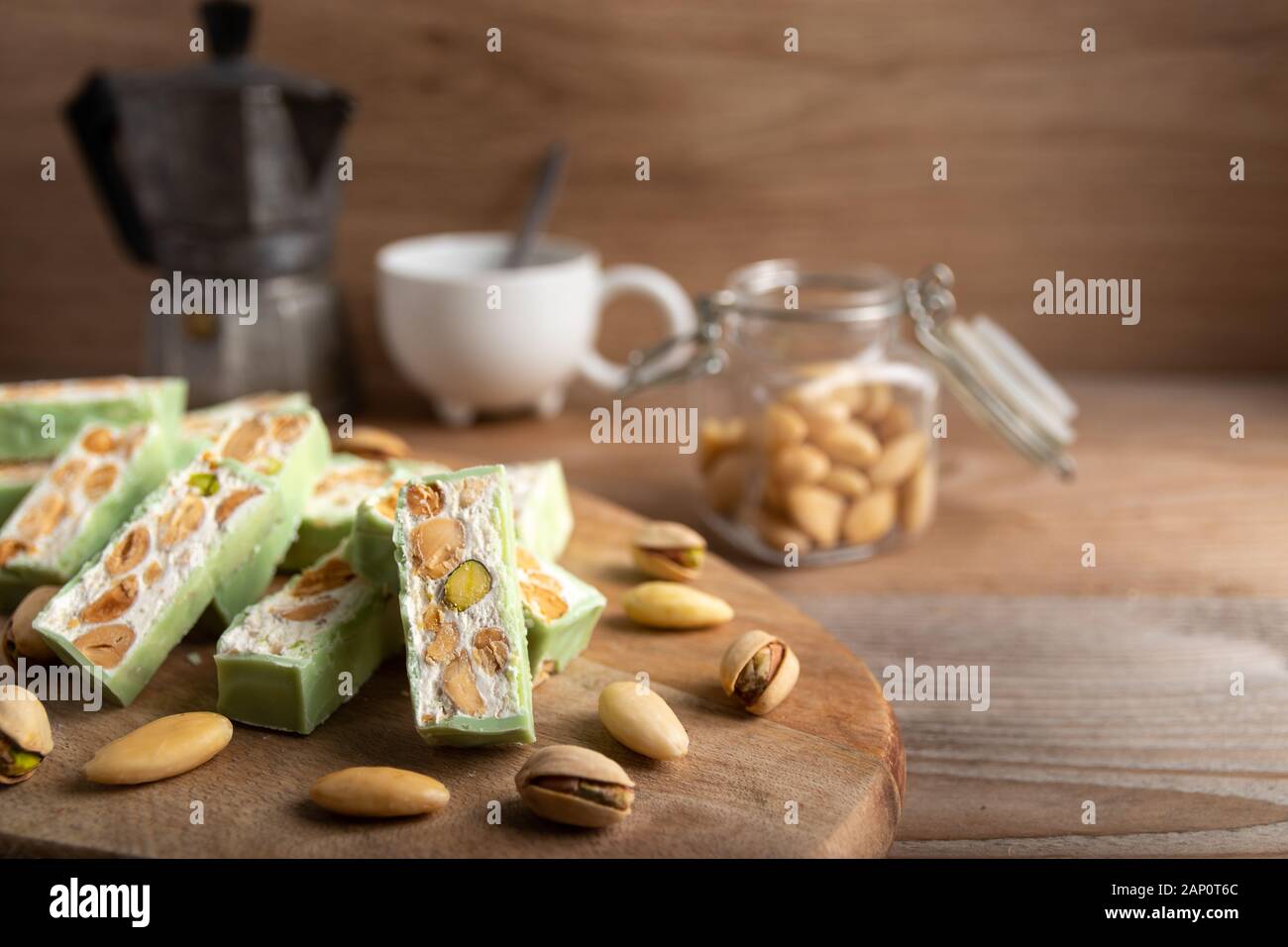 Nougat bio faites avec du miel, pistache, noisette, amande et noix sur une table en bois en arrière-plan. Banque D'Images