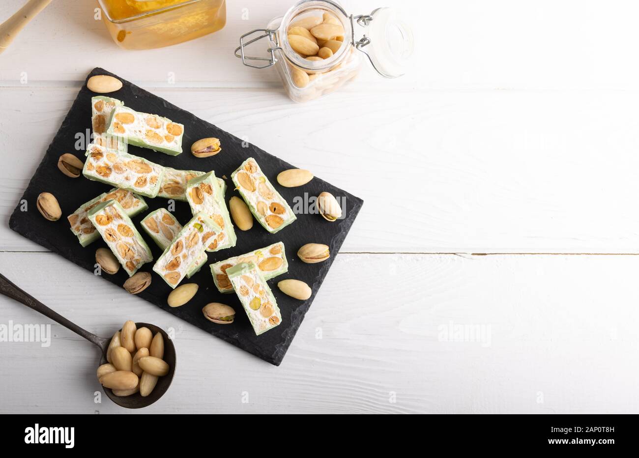 Nougat bio faites avec du miel, pistache, noisette, noix et amandes, sur un fond blanc. Banque D'Images