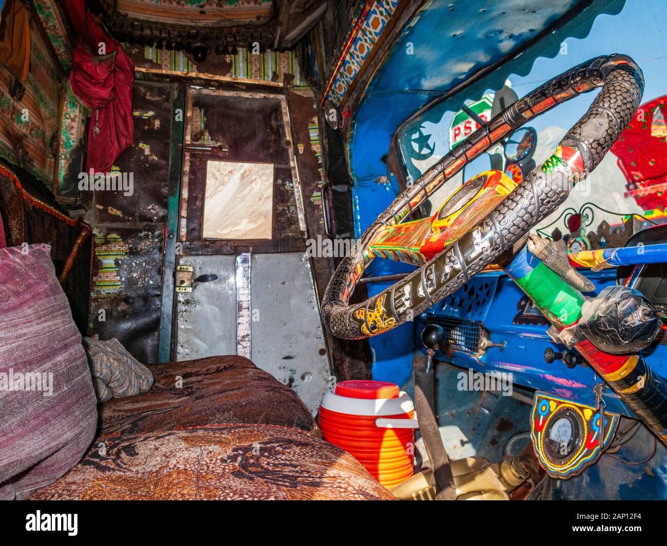 Vue à l'intérieur de la cabine d'un camion coloré et peint, conduisant sur les routes poussiéreuses de l'autoroute Karakorum Banque D'Images