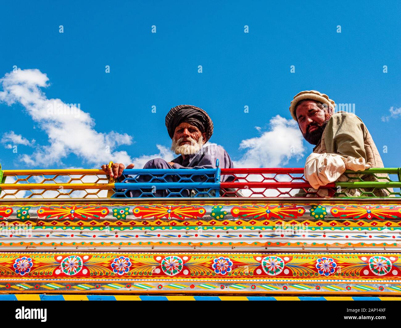 Deux hommes sont assis sur le toit d'un bus coloré et peint Banque D'Images
