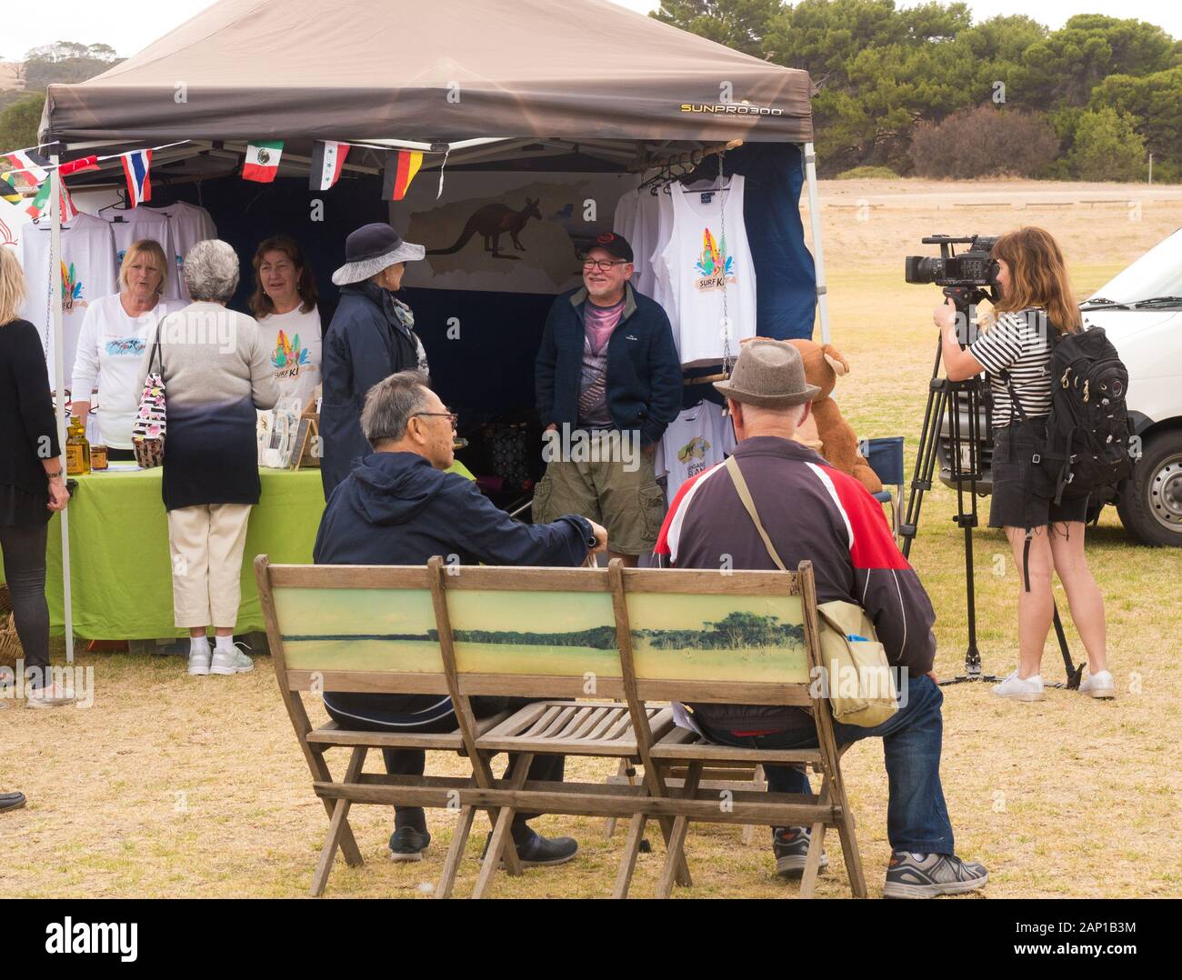 Jeune femme enregistre des séquences vidéo de Penneshaw market assisté par les passagers du Sun Princess Cruise ship sur Kangaroo Island, Australie. Banque D'Images