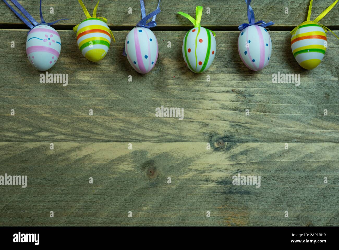 Œufs de Pâques colorés avec ruban sur un fond en bois. Espace de copie sous, vue de dessus Banque D'Images