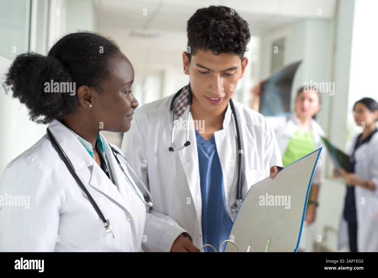 Portrait de médecins, de race mixte. Une fille noire, avec un mec mexicain, en blouse blanche, avec les stéthoscopes, tient des documents médicaux, une consultation, une Banque D'Images