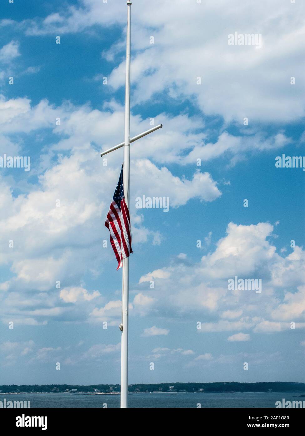 Drapeau américain en berne contre un parfait ciel bleu avec des nuages Banque D'Images