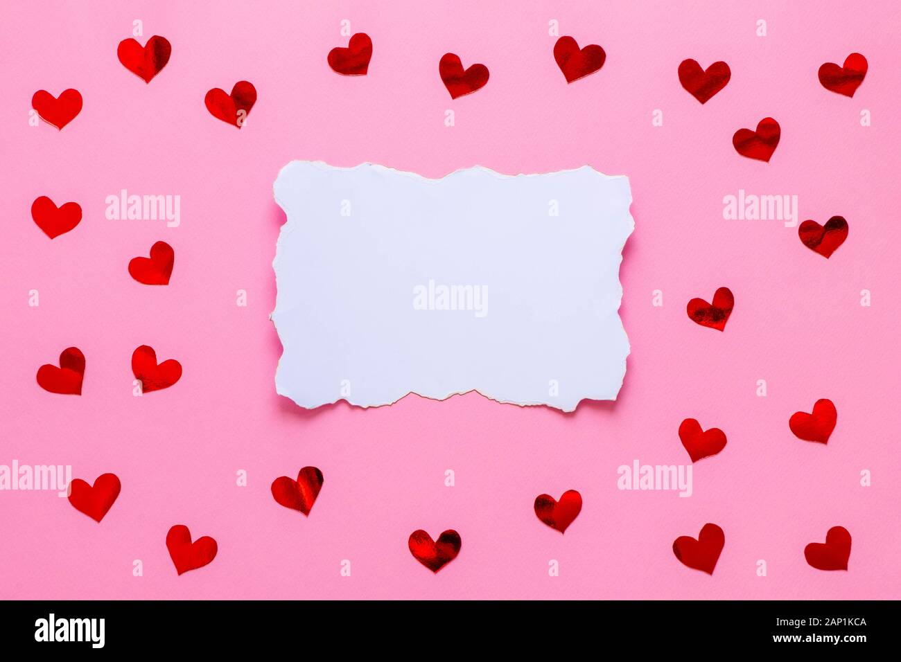 Liste papier blanc vide avec coeurs rouges confettis sur fond rose Banque D'Images