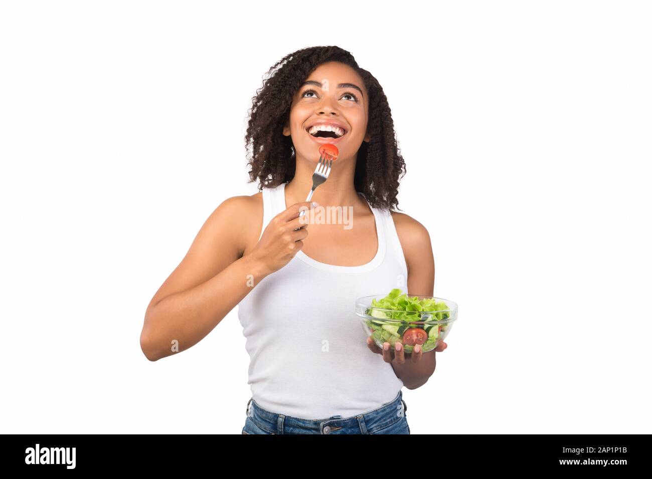 Happy young woman eating salad afro avec la fourchette Banque D'Images