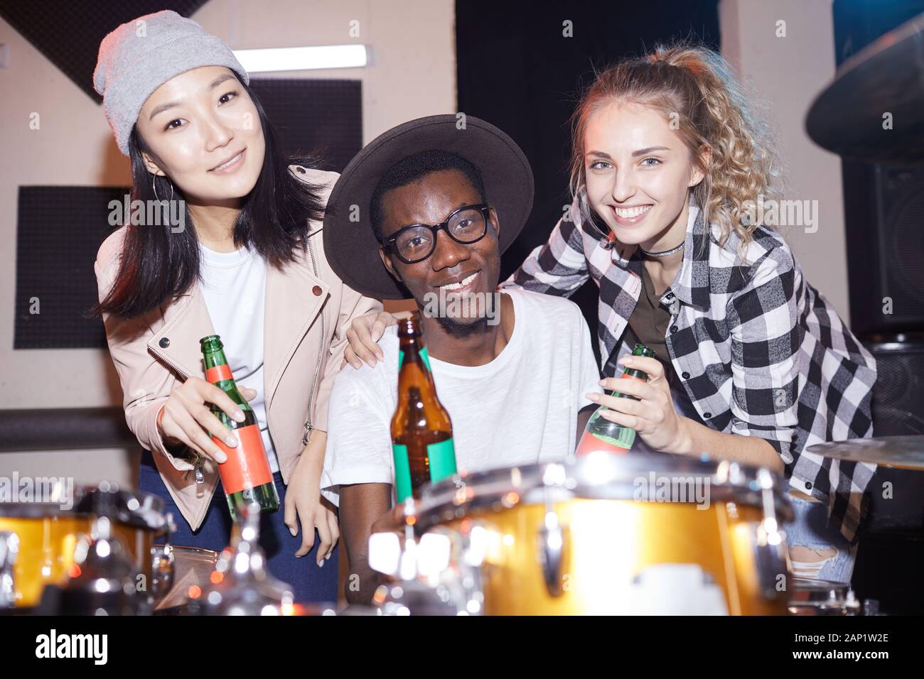 Portrait de groupe multi-ethnique de personnes qui posent avec les bouteilles de bière dans Studio, tourné avec flash Banque D'Images