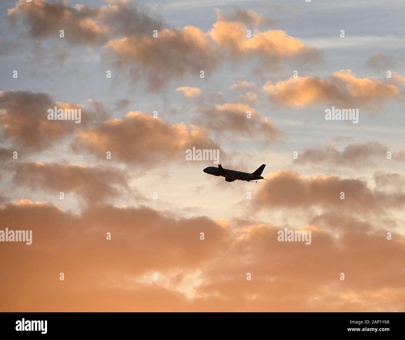 Un avion commercial prend son décollage à l'aéroport international d'Orlando au coucher du soleil. Banque D'Images