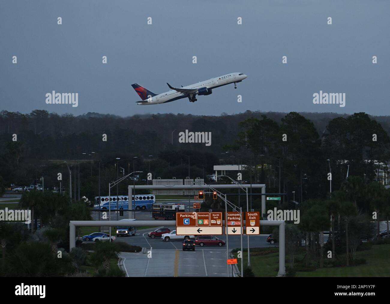 Un avion de Delta Airlines prend son décollage à l'aéroport international d'Orlando alors que les autobus prennent les passagers. Banque D'Images