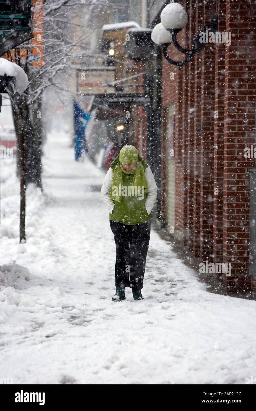 Les misérables femme gel voguant le long d'une rue de la ville, pendant une tempête Banque D'Images