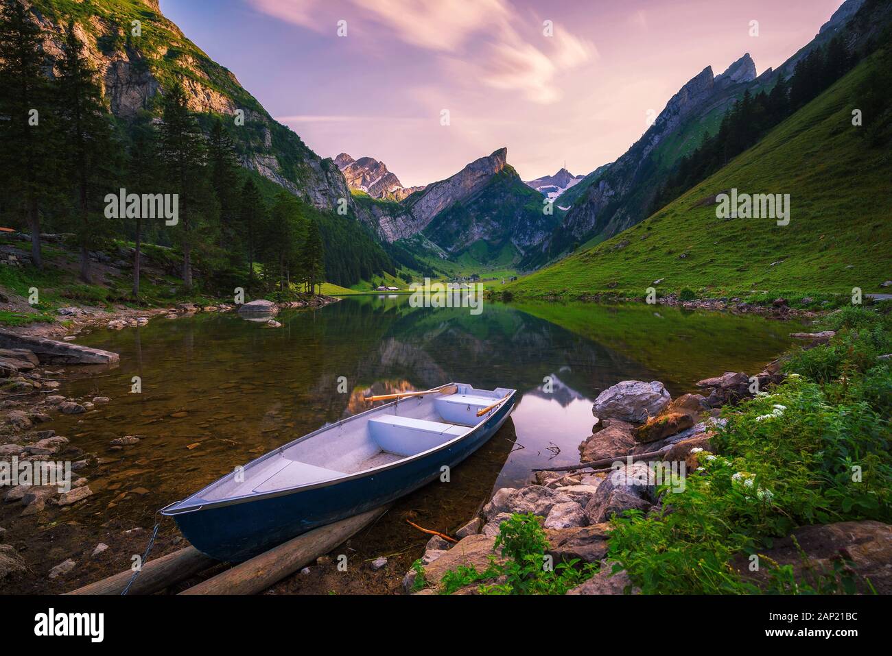 Coucher de soleil sur le lac Seealpsee avec un bateau dans les Alpes suisses, Suisse Banque D'Images