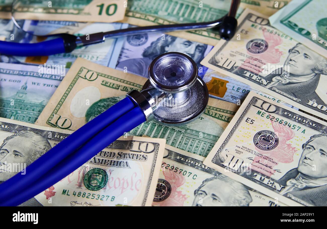 Concept des dépenses coût médical isolé : blue stethoscope on pile de papier-monnaie US dollar bank note Banque D'Images