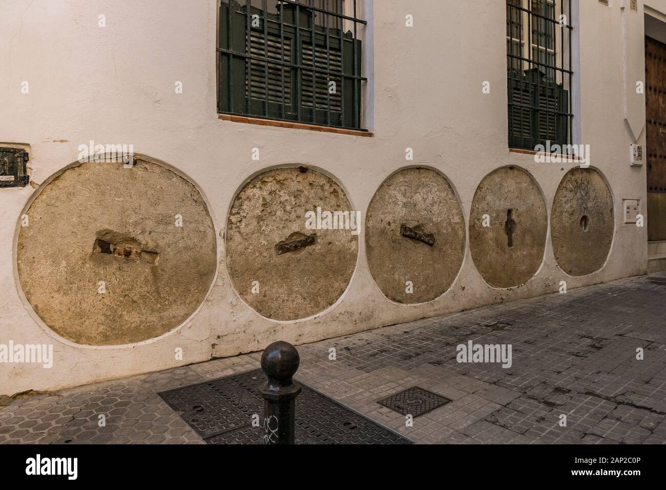 Moulin à meules, roues intégrées à la façade, la protection de mur, Calle Santa Teresa, Barrio Santa Cruz, Sevilla, Andalousie, espagne. Banque D'Images