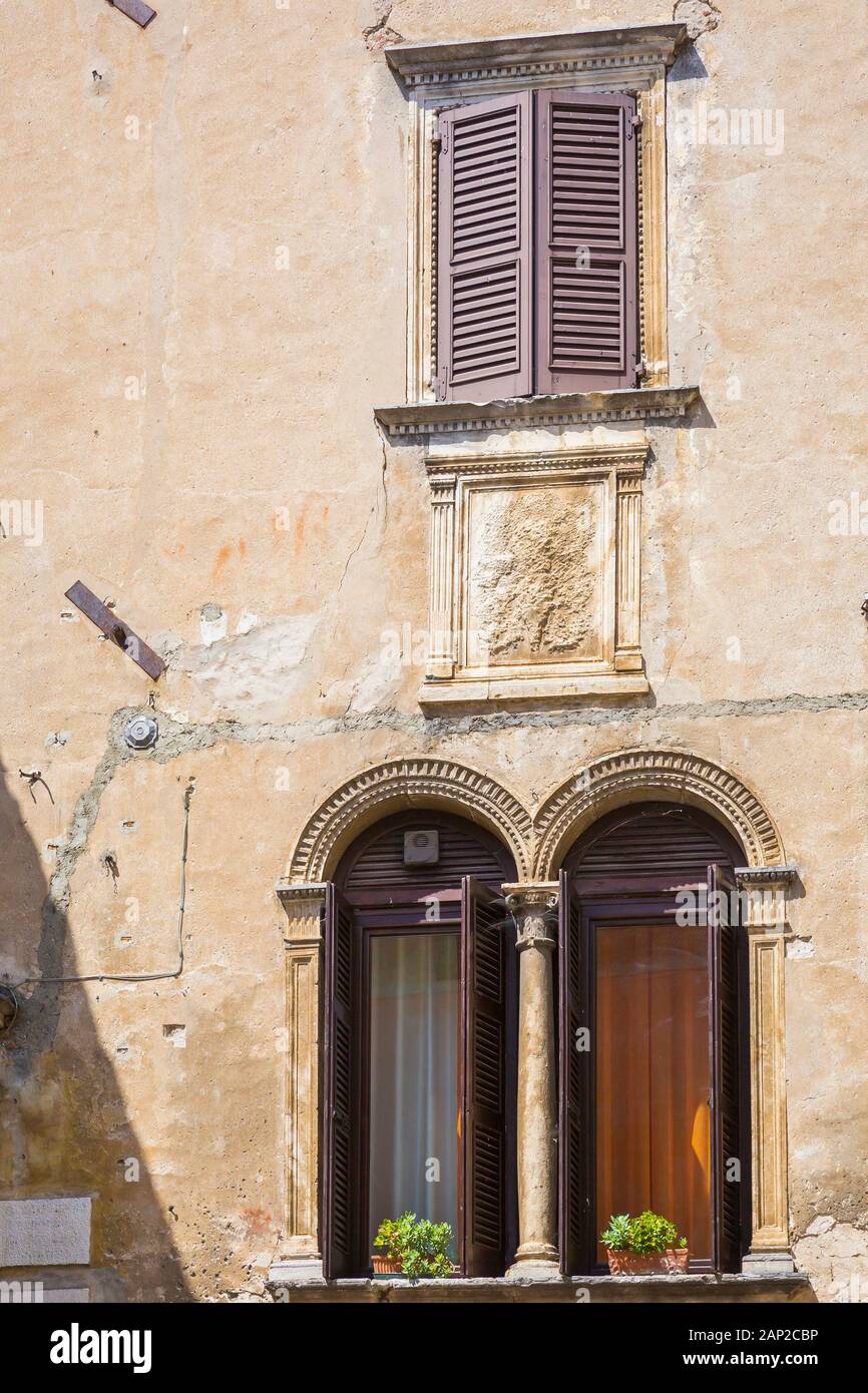 Vieille façade de maison, de grandes fenêtres, volets ouverts. dans village touristique populaire Garda, Italie Banque D'Images