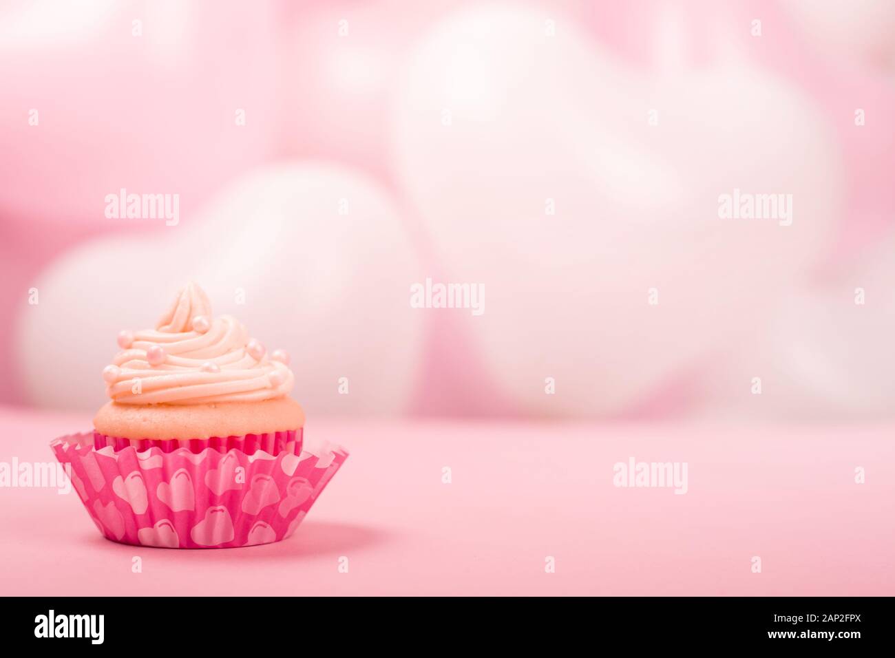 Amour saint valentin décoration cupcake à la crème de rose et blanc ballons coeur partie arrière-plan avec copie espace pour le texte Banque D'Images