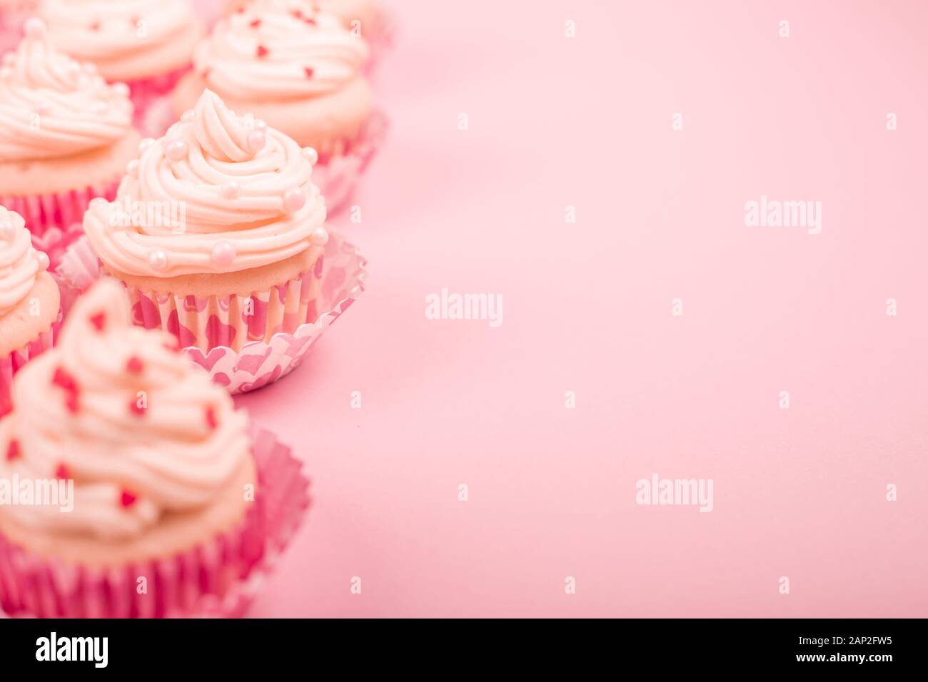 Valentine day love cupcakes décoration crème et coeurs sur fond rose avec copie espace pour le texte Banque D'Images