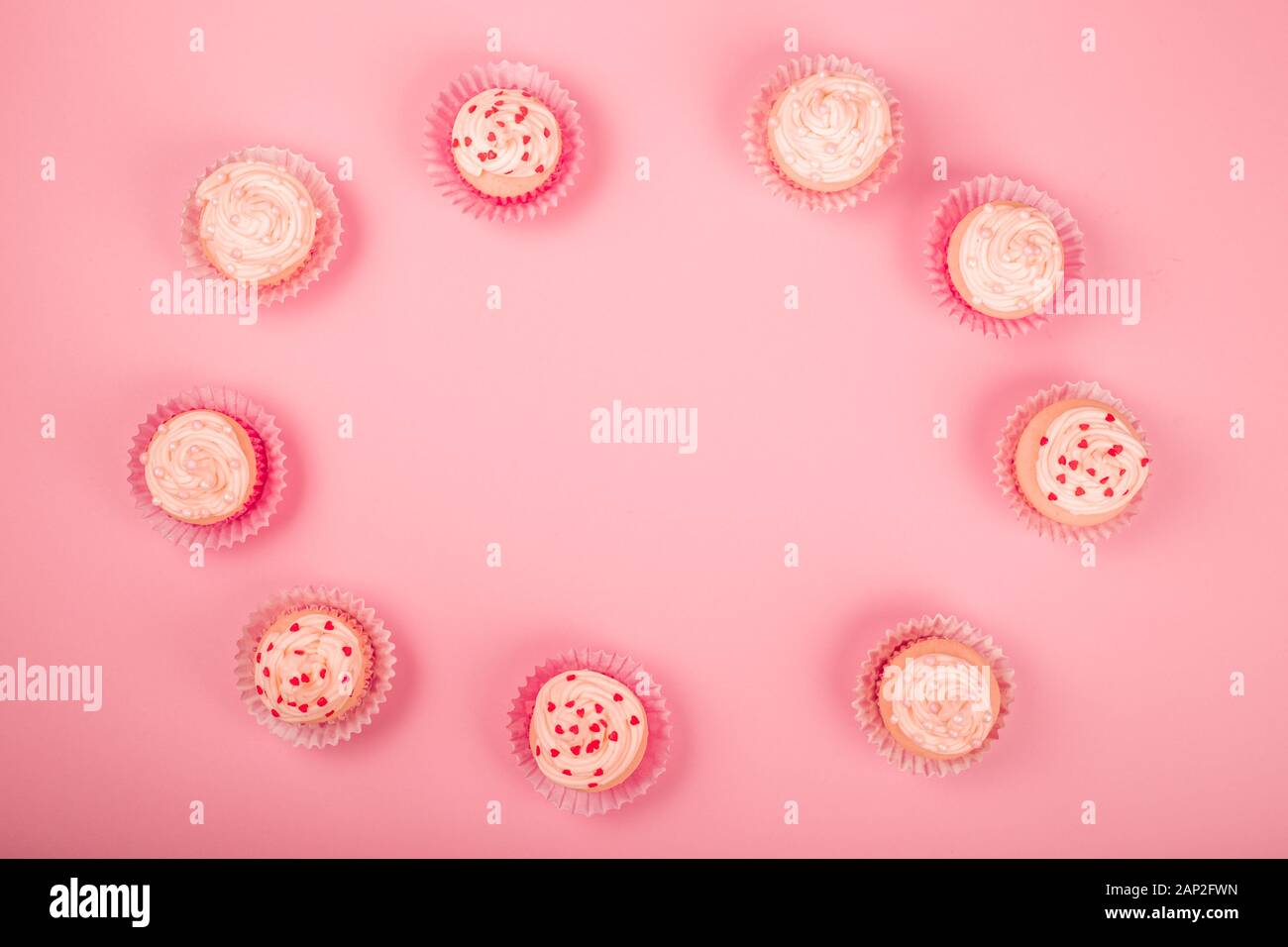Valentine day love cupcakes décoration crème et coeurs sur fond rose border frame with copy space for text Banque D'Images