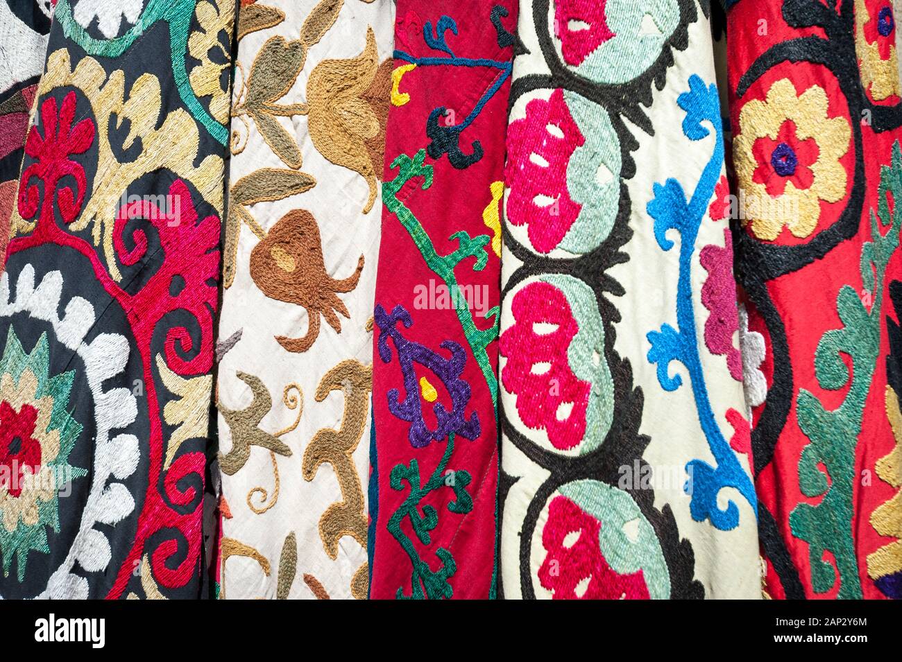 Tissu turc texturé coloré avec broderie rouge vif accrochée à l'extérieur sur un fond plein format Banque D'Images