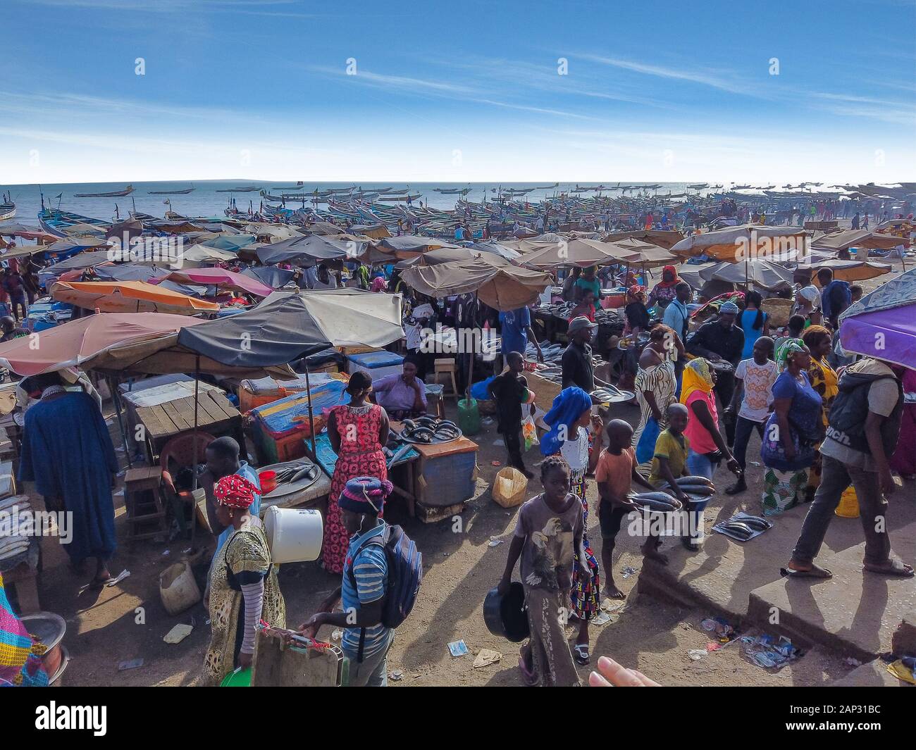 MBour, Sénégal- le 25 avril 2019 : hommes et femmes sénégalais non identifiés du marché aux poissons de la ville portuaire près de Dakar. Il y a des étals de vente et Banque D'Images