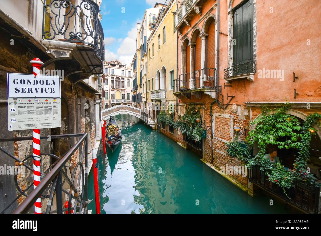 Un gondolier attend les clients touristiques à un point de service, gondole sur un pittoresque petit canal à Venise, Italie Banque D'Images