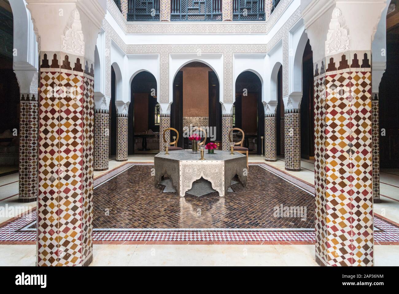 Intérieur d'un riad avec des piliers et des motifs islamiques en mosaïque Banque D'Images