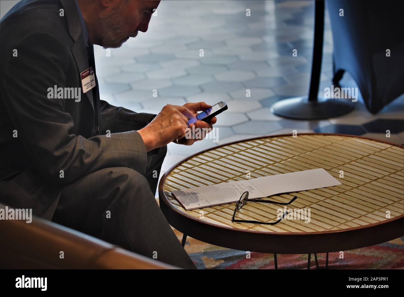 Homme d'affaires à l'hôtel travaillant sur le téléphone portable avant de se réunir de Toastmasters Banque D'Images