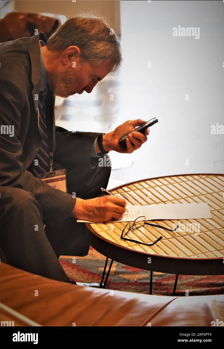 Homme d'affaires à l'hôtel travaillant sur le téléphone portable avant de se réunir de Toastmasters Banque D'Images