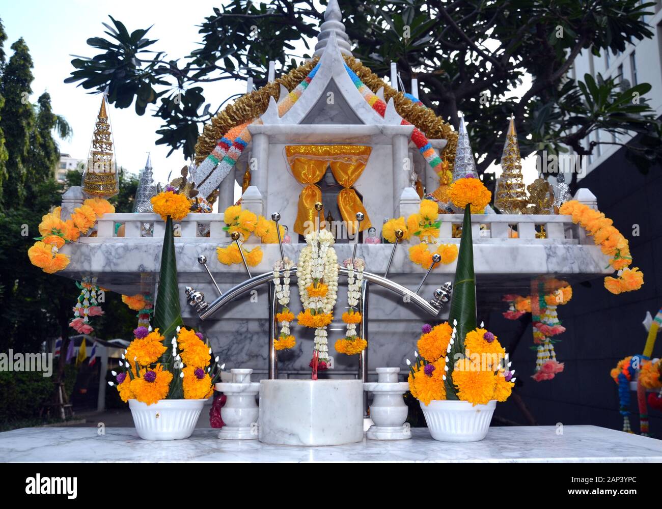 Des guirlandes colorées ou Phuang Malai décorent une maison d'esprit ou un sanctuaire thaïlandais typique à l'extérieur d'un hôtel de Bangkok, Thaïlande, Asie Banque D'Images