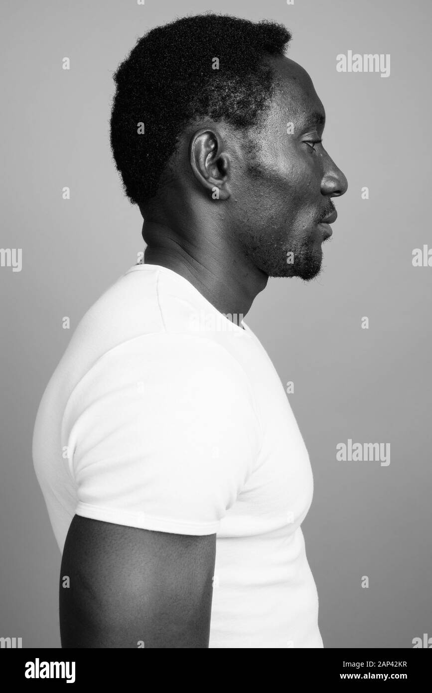 Beau jeune homme africain contre l'arrière-plan gris Banque D'Images